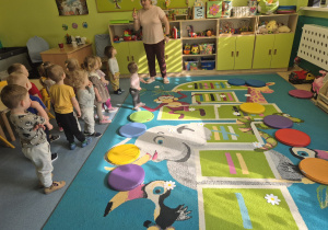 dzieci stoją , na podłodze leżą kwiatuszki