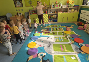 dzieci stoją , opiekunka tłumaczy jak będą się bawić