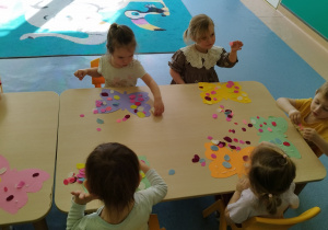 dzieci przy stoliku ozdabiają motyle