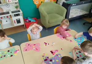 dzieci przy stoliku ozdabiają motyle