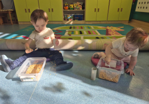 dzieci bawią się produktem , który mają w pudełku