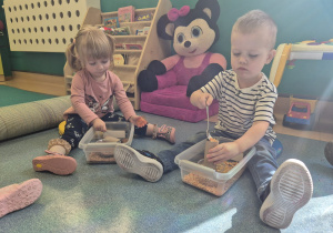 dzieci używając łyżki przesypują produkty