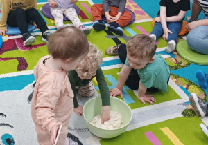 chętne dzieci ugmniatają ciasto w misce