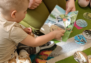 chłopiec przykłada do dużego obrazka, mały wybrany przez siebie