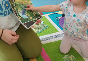 opiekunka trzyma obrazek, a dziewczynka przykłada do niego wybrany przez siebie