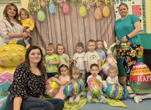 dzieci siedzą i stoją, opiekunki stoją, jedna siedzi- pozują do zdjęcia