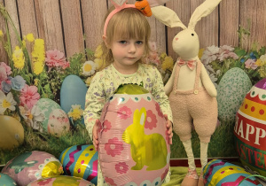 dziewczynka z opaska uszy królika na głowie trzyma balona pisakę