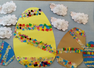 na tablicy wiszą wyklejane przez dzieci baranki oraz pisanki