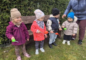 dzieci stoją trzymają łyżki z jajkiem