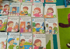 na dywanie leżą ilustracje z sytuacjami, w których dzieci muszą uważać