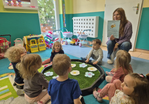 opiekunka pokazuje dzieciom pszczołę na rysunku