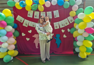 mama trzyma córkę na rękach i pozują do zdjęcia