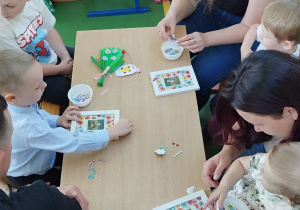 rodzice z dziećmi przyklajają naklejki