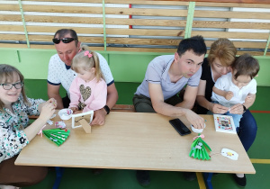 dzieci wraz z rodzicami ozdabiają ramki