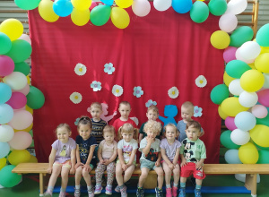 dzieci siedzą na ławce , a niektóre stoją