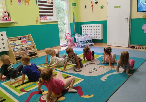 dzieci chodzą po dywanie w pozycji odwrotnych czworaków unosząc pupy jak kraby