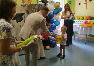 chłopiec trzyma piłkę, przybija piątkę panu burmistrzowi