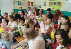 rodzice oraz dzieci siedzą na ławkach