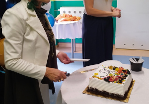 pani dyrektor stoi przed stolikiem, na którym stoi tort