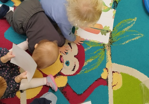dzieci siedzą na dywanie szukają brakujących połówek warzywnych puzzli